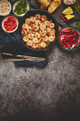 Image showing Grilled shrimps in cast iron grilling pan with fresh lemon, parsley, chili, garlic white wine sauce