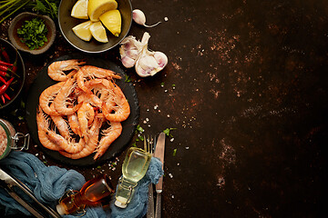 Image showing Seafood composition with shrimps or prawns. Seved on dark background with many ingredients. Flat lay