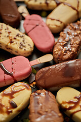 Image showing Ice cream on stick coated with various chocolate glazes and toppings. Top view, flat lay