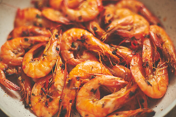 Image showing Close up of tasty fried whole prawns with parsley sprigs and garlic. Delicious seafood concept