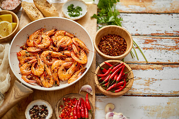 Image showing Top view of prawns shrimps roasted on pan with herbs placed on rustic wooden kitchen table