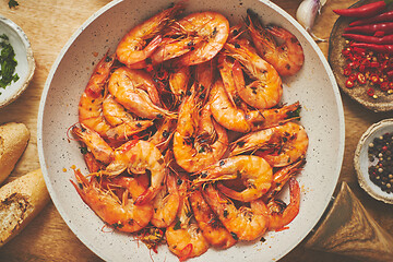 Image showing Traditional fried tiger prawn with garlic bread as top view served in a white frying pan