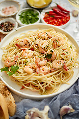 Image showing Spaghetti with shrimps on white ceramic plate and served with glass of white wine