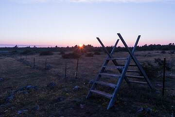 Image showing Traditional wooden stile at a fence by sunset