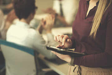 Image showing blonde businesswoman working on tablet at office