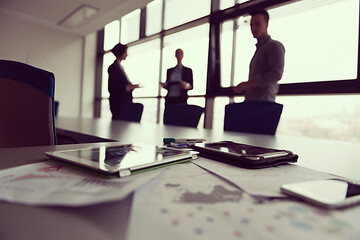 Image showing close up of tablet, business people on meeting in background