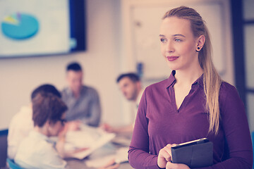 Image showing blonde businesswoman working on tablet at office