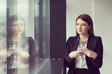 Image showing Business Girl Standing In A Modern Building Near The Window With