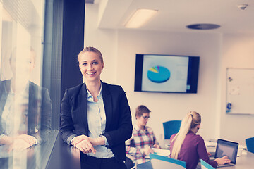 Image showing portrait of young business woman at office with team on meeting 