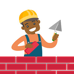 Image showing African-american bricklayer building a brick wall.