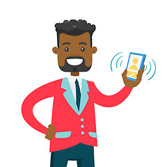 Image showing Young african man holding ringing mobile phone.
