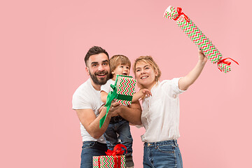 Image showing happy family with kid together and smiling at camera isolated on pink