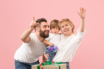 Image showing happy family with kid together and smiling at camera isolated on pink