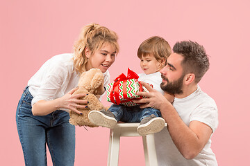 Image showing happy family with kid together and smiling at camera isolated on pink