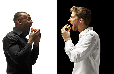 Image showing Men eating a hamburger and donut on a black and white background