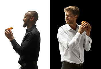 Image showing Men eating a hamburger and donut on a black and white background