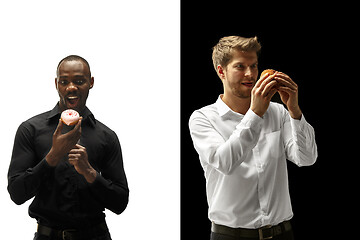 Image showing Men eating a hamburger and donut on a black and white background