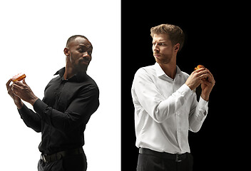 Image showing Men eating a hamburger and donut on a black and white background