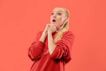 Image showing Beautiful woman looking suprised isolated on coral