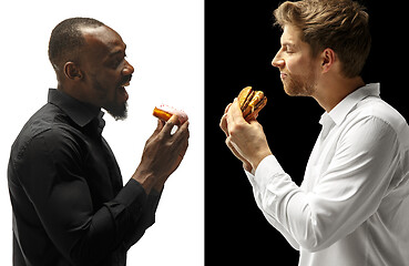 Image showing Men eating a hamburger and donut on a black and white background