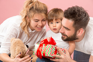 Image showing happy family with kid together and smiling at camera isolated on pink