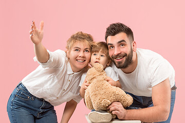 Image showing happy family with kid together and smiling at camera isolated on pink