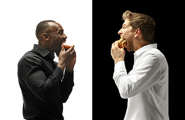 Image showing Men eating a hamburger and donut on a black and white background