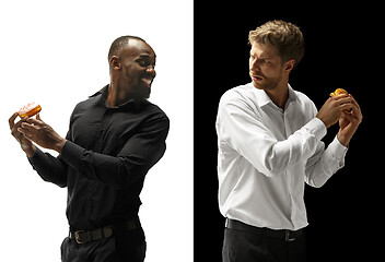 Image showing Men eating a hamburger and donut on a black and white background