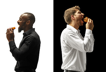 Image showing Men eating a hamburger and donut on a black and white background