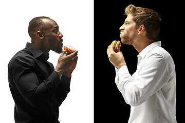 Image showing Men eating a hamburger and donut on a black and white background