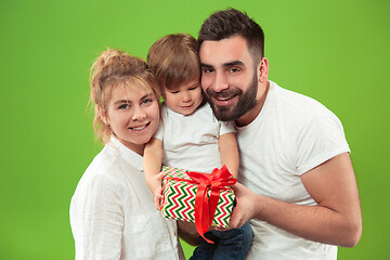 Image showing happy family with kid together and smiling at camera isolated on green