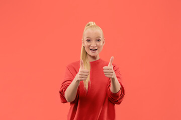 Image showing The happy business woman standing and smiling against coral background.
