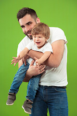 Image showing happy family with kid together smiling at camera isolated on green