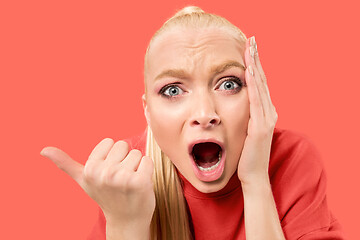 Image showing Beautiful woman looking suprised isolated on coral