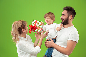 Image showing happy family with kid together and smiling at camera isolated on green
