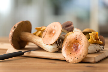 Image showing edible mushrooms on wooden cutting board and knife