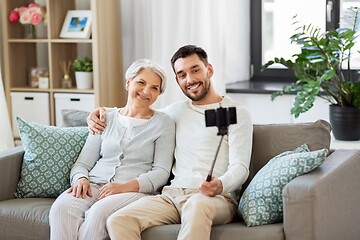 Image showing senior mother with adult son taking selfie at home