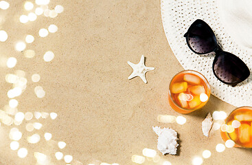 Image showing cocktails, sun hat and sunglasses on beach sand