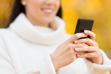 Image showing woman using smartphone in autumn park