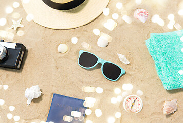 Image showing camera, passport, sunglasses and hat on beach sand