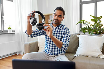 Image showing male blogger with headphones videoblogging at home