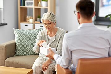 Image showing psychologist giving tissues to senior woman client