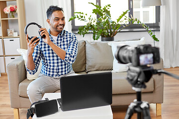 Image showing male blogger with headphones videoblogging at home