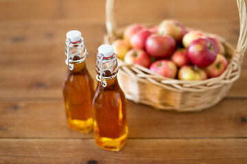 Image showing apples in basket and bottles of juice on table