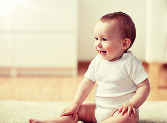 Image showing happy baby boy or girl sitting on floor at home