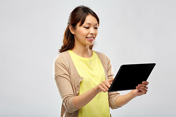 Image showing happy asian woman using tablet computer