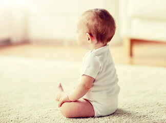 Image showing happy baby boy or girl sitting on floor at home