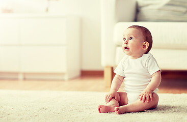 Image showing happy baby boy or girl sitting on floor at home