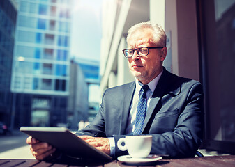 Image showing senior businessman with tablet pc drinking coffee