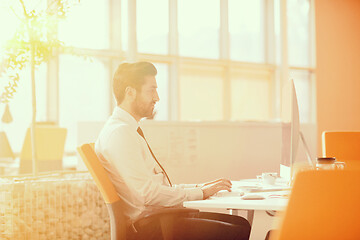 Image showing relaxed young businessman first at workplace at early morning